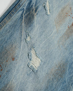 ヴィンテージのダメージ加工ウォッシュジーンズ